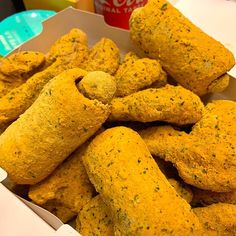 a box filled with fried food next to a cup