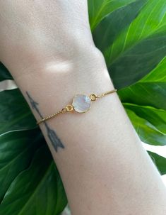 This minimalist style moonstone bracelet is perfect for everyday wear. It's beautiful on its own, but also makes a great layering piece. Created with a gold electroplated rainbow moonstone connector that is attached to a dainty gold plated chain with a slider bead that makes it adjustable. It is finished off with two gold ball ends. #gemstonejewelry #moonstone #minimalist Spiritual Gold Bracelets With Moon Phase Detail, Spiritual Gold Bracelets With Moon Phase, Minimalist Moon Phase Bracelet, Spiritual Gold Bracelets With Moonstone, Trendy Gold Bracelets With Natural Stones, Adjustable Gold Moonstone Bracelet, Adjustable Gold Bracelets With Moon Phase, Minimalist Adjustable Gemstone Chain Bracelet, Adjustable Moonstone Bracelets For Everyday