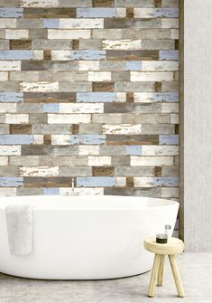 a white bath tub sitting next to a wall with wooden planks on the walls