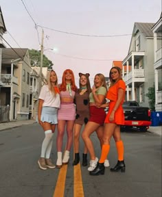 four girls are standing in the street with their arms around each other