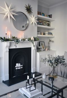 a living room filled with furniture and a fire place in front of a mirror on the wall