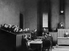 an old courtroom full of men in suits and ties sitting at desks, with one man