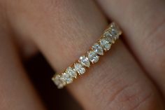 a woman's hand with a yellow gold band and diamond ring on her finger