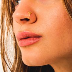 a close up of a woman with a nose piercing on her left side of the face