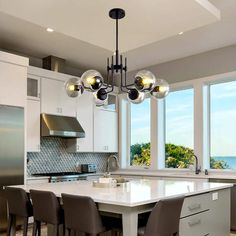 a large kitchen with an island in the middle and lots of chairs on top of it