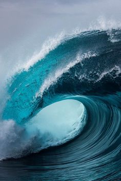 a large blue wave breaking into the ocean