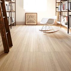 an empty room with bookshelves and rocking chair