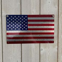 an american flag is hanging on the side of a wooden fence with metal brackets and screws