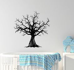 a baby crib with a tree decal on the wall