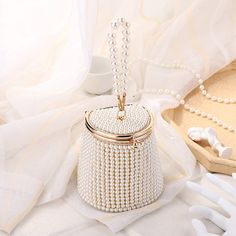 Introducing the Gemma Pearl Beaded Mini Bucket Evening Bag – a sophisticated and luxurious piece of accessory that'll make you shine. Perfect for your formal occasions with its exquisite yet elegant design adorned with pearls and a beaded finish, this mini barrel bag is truly a timeless classic. Enjoy the timeless beauty in the highest quality. SIZE: W12.5 cm x H 10.5cm x D8cm Gender: WOMENShape: BarrelMain Material: ABS ThermoplasticLining Material: PolyesterHardness: HARDDecoration: BeadingDec Bridal Clutch Purse, Pearl Clutch, Bridal Handbags, Motifs Perler, Pearls Diy, Pearl Bag, Bridal Clutch, Pearl Design, Beaded Clutch