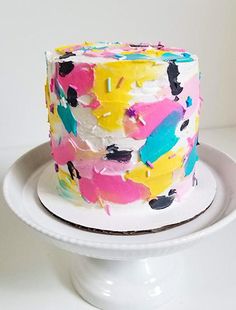 a multicolored cake sitting on top of a white plate