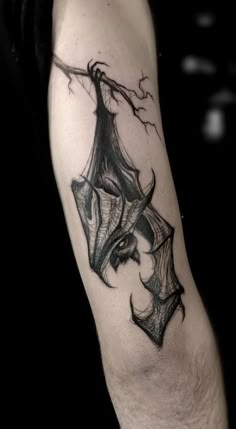 a man's arm with a bat tattoo on it