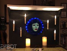 a woman's face is surrounded by candles in front of a mirror with blue lights