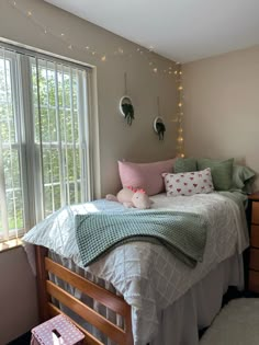 a bedroom with a bed, dresser and window in the corner that has lights on it