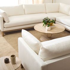 a living room with white couches and a coffee table