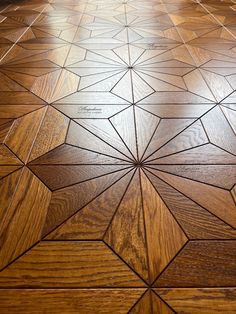 a wooden floor with an intricate design on it's surface and light shining through the top