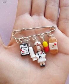 a person holding a small pin with some food on it's back and other items attached to it