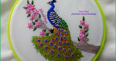 a peacock is sitting on a tree branch with pink flowers and green trimmings