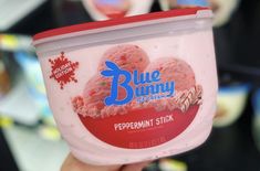 a person holding up a tub of blue bunny ice cream in it's hand