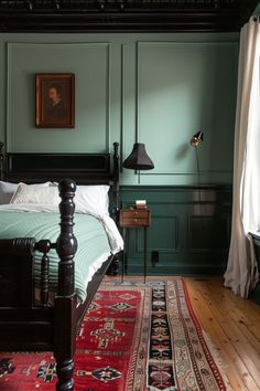 a bedroom with green walls and wooden floors