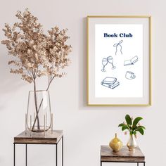 two tables with vases and flowers on them in front of a book club poster