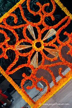 an orange and yellow flower arrangement on the ground in front of a building with a sign that says 350