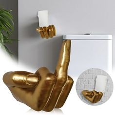 a toilet with a gold painted hand holding a candle holder next to it and a potted plant in the corner