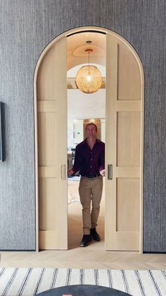 A man closes a pair of arched double pocket doors in an upscale home. As the doors come together, they stop and slowly soft close. Sliding Doors In The Wall, Bedroom Door To Outside, Interior Cavity Sliders, Sliding Arch Doors, Large Doors Interior, Roller Doors Interior, Cavity Slider Doors, Large Interior Doors, Arched Pocket Doors Interior