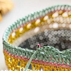 there is a crochet basket that has been made with beads and yarns