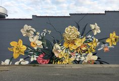 a large mural on the side of a building with flowers painted on it's sides