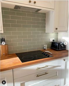 a stove top oven sitting inside of a kitchen next to a counter with a toaster on it