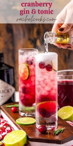 two glasses filled with red and green drinks on top of a wooden cutting board next to bottles