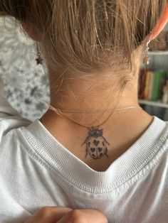 a ladybug tattoo on the back of her neck