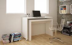 a computer desk with a laptop on top of it next to a stack of books