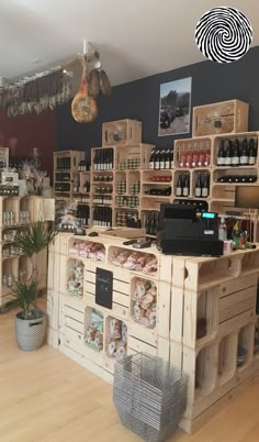 the inside of a wine shop with wooden crates and shelves filled with bottles, glasses, and other items