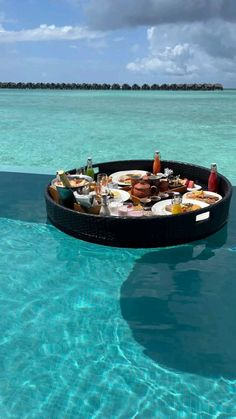 an oval table with food on it in the water