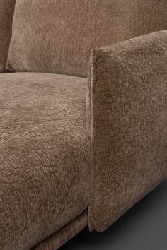 a close up view of a brown couch with pillows on it's back end