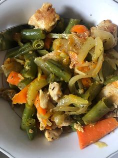 a white bowl filled with green beans, carrots and chicken