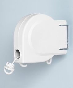 a white wall mounted toilet paper dispenser on a blue wall with a cord attached to it