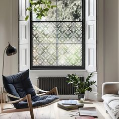 a living room filled with furniture and a window covered in frosted glass coverings