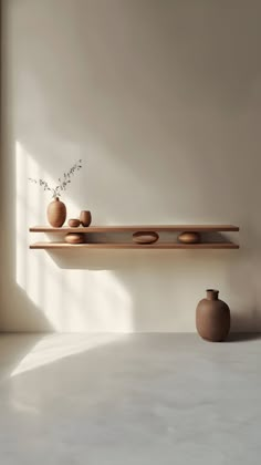 three vases and two bowls on a shelf