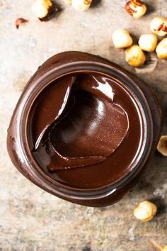 a jar filled with chocolate and nuts on top of a table