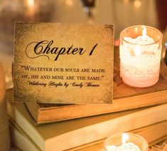 a table topped with two candles and a sign that says, chapter 1 whatever our soul is made of, his and mine are the same