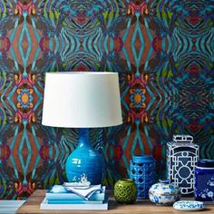 a blue vase sitting on top of a table next to a lamp and other items