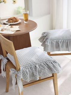 two wooden chairs sitting next to each other near a table with pastries on it