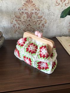 a crocheted purse sitting on top of a wooden table