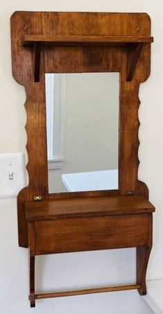 an old wooden vanity with mirror and light switch