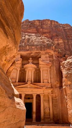 an ancient building carved into the side of a cliff in wadih - eb, jordan