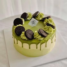 a green cake with cookies and oreos on top