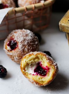 powdered sugar covered doughnuts with berries on the side